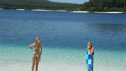 Two people standing at the shore of a lake