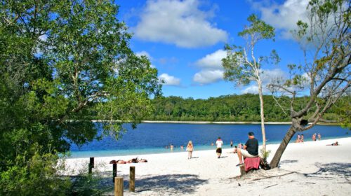 Several tour-goers relaxing on the shore of a lake
