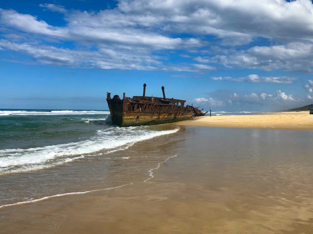 Shipwreck on beach with water