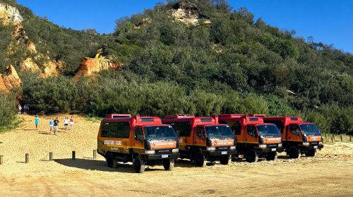 Four tour vehicle parked next to each other in a line