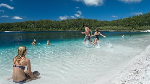 Swimmers splashing in the water at Lake McKenzie